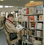 Dame bij boekenrek met makkelijke boeken.